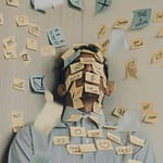 A person sits against a wall, eyes closed, with their face and body covered in sticky notes. The notes include messages like “Take a break,” “Stop,” “Offline,” “Make money,” “Chill,” and various doodles. Additional notes are floating in the air, emphasizing a sense of overwhelm, multitasking, or burnout.