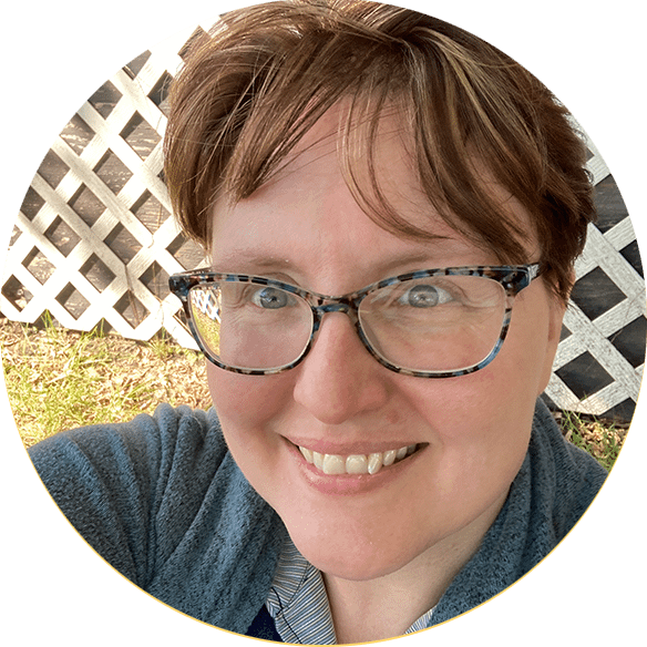 Woman with short hair and blue rimmed glasses