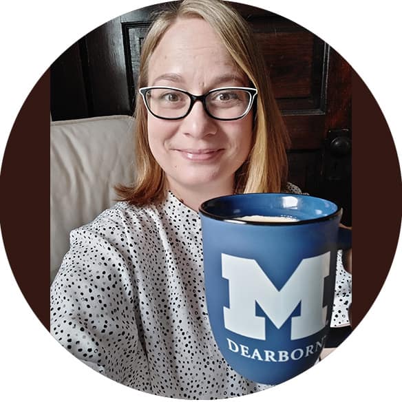 Headshot of a smiling woman holding a coffee cup