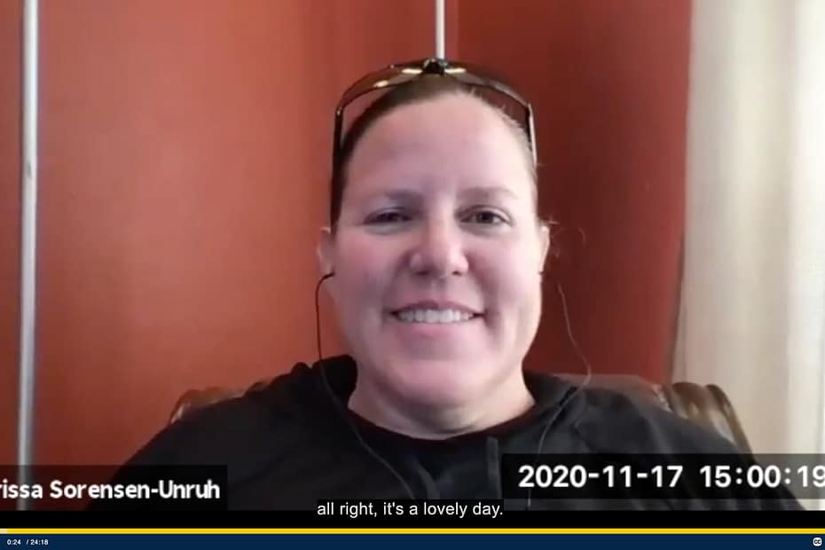 Screenshot from zoom conversation is of a smiling woman with sunglasses on her head.