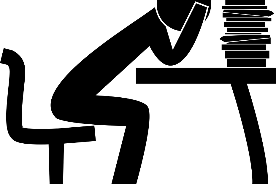 Black illustration of student sitting at desk with hands on head in front of a stack of books. Evokes feelings of being frustrated by studying